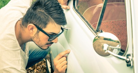 examining a scratch on car