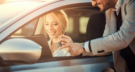 women in rental car holding keys