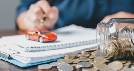 man with toy car and jar with coins